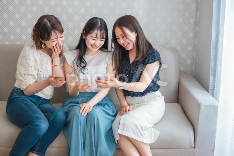 スマホを使う女性たち（爆笑） スマートフォン,スマホ,女子会の写真素材