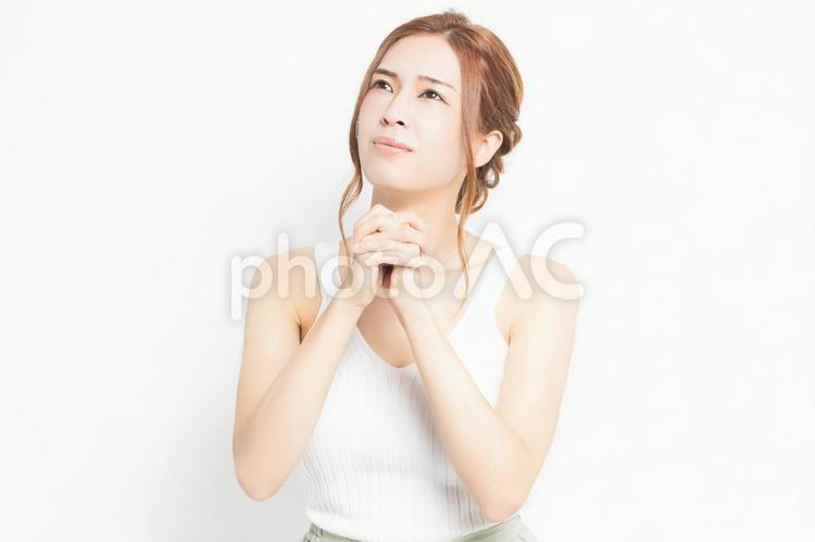 お願いのジェスチャーをする若い女性 女性,お願い,ポーズの写真素材
