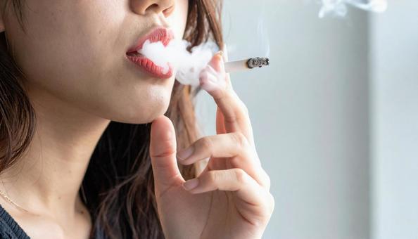 喫煙する若い日本人女性の口元 喫煙する若い日本人女性の口元の写真