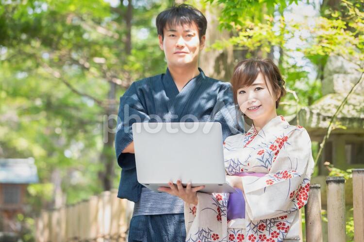 パソコンを持つ浴衣姿の女性 浴衣,ノートパソコン,観光ガイドの写真素材