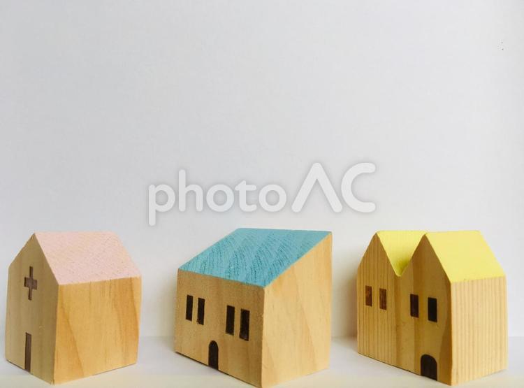 おもちゃの木の家 三軒ピンクの屋根 黄色い屋根 青い屋根  白い背景 白いバックグラウンド おもちゃの木の家,ピンク色の屋根,黄色い屋根の写真素材