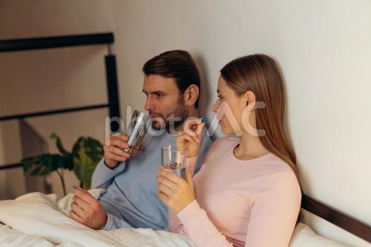これから薬を飲むカップルの横顔 男性,女性,ロングヘアの写真素材