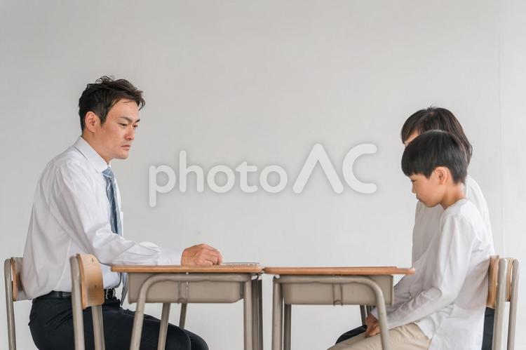 学校で男性教師と三者面談する悩む親子 面談,学校,三者面談の写真素材