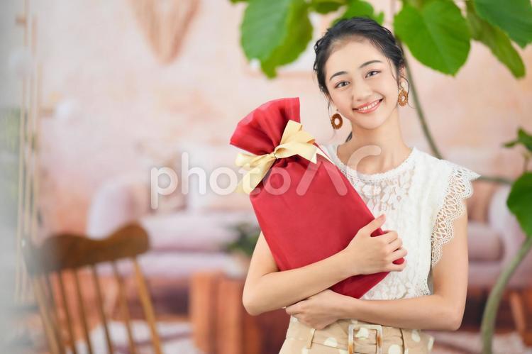 プレゼントを抱えて持つ女性 女性,プレゼント,抱えて持つの写真素材