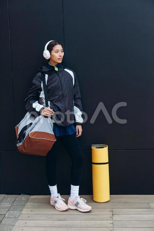 バッグを持つ女性と横にヨガマット 女性,ヘッドフォン,人物の写真素材