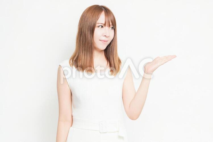 手で案内のジェスチャーをする若い女性 女性,案内,ジェスチャーの写真素材