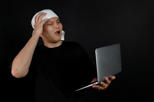 パソコンで驚く男性 パソコンで驚く男性の写真