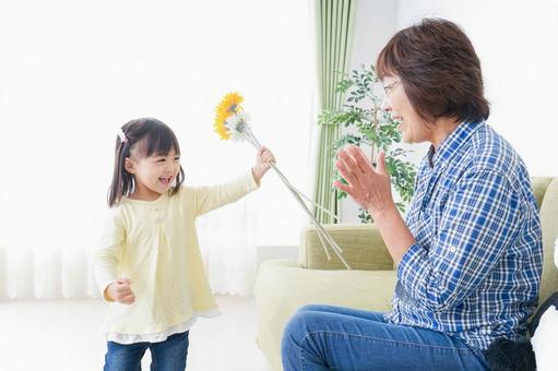 祖母に花をあげる子ども 祖母に花をあげる子ども 育児,実家,家族の写真素材