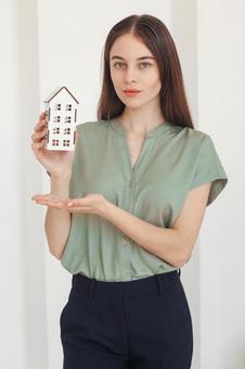家の模型を持った女性スタッフ 保険業,事務職,接客業の写真素材