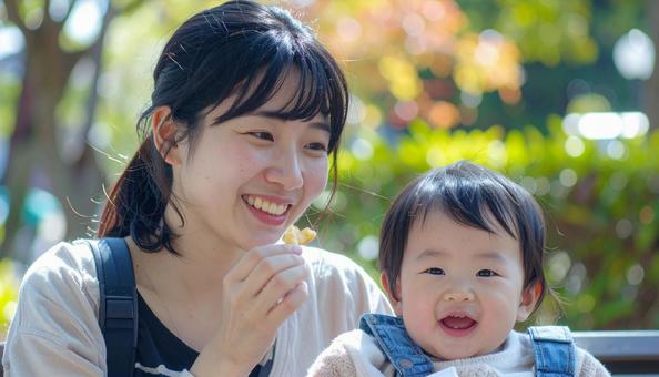 公園でおやつを食べる親子 公園でおやつを食べる親子の写真