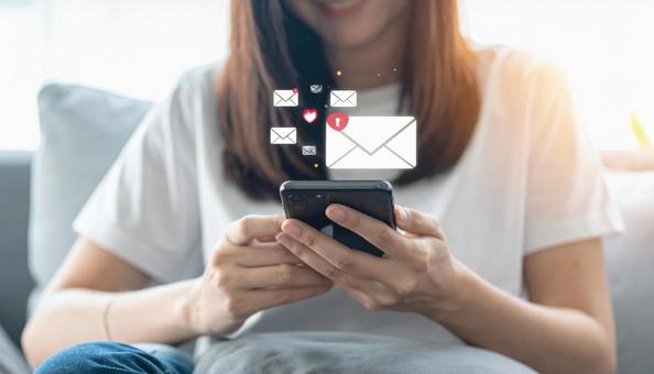 携帯電話でソーシャルメディアを楽しむ女性 携帯電話でソーシャルメディアを楽しむ女性の写真