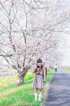 桜の木の下でピースをする女の子 桜の木の下でピースをする女の子の写真