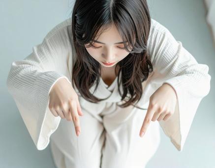 下を指差す女性の写真