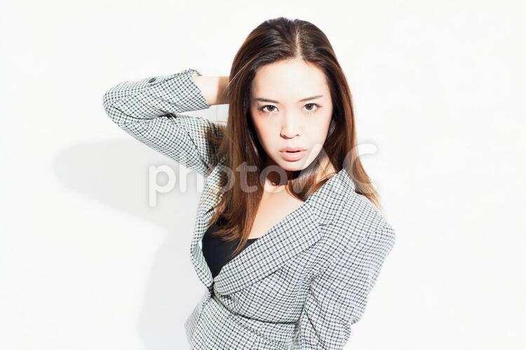 白い背景の前に立ってポーズをとる若いビジネスウーマン 女性,白背景,立つの写真素材