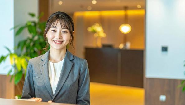 来客を迎える受付の女性 来客を迎える受付の女性の写真