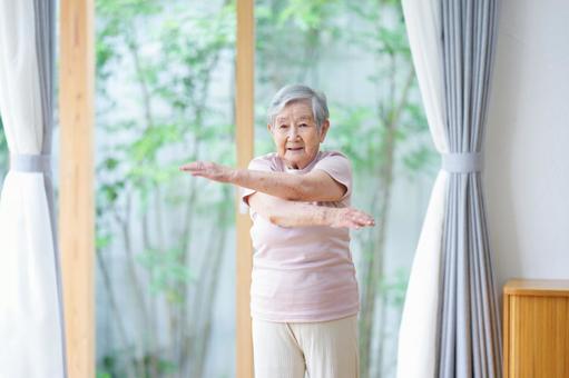 笑顔で手を伸ばしクロスする女性 女性,体操,真顔の写真素材