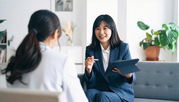 タブレットを使って説明する女性営業マン タブレットを使って説明する女性営業マンの写真
