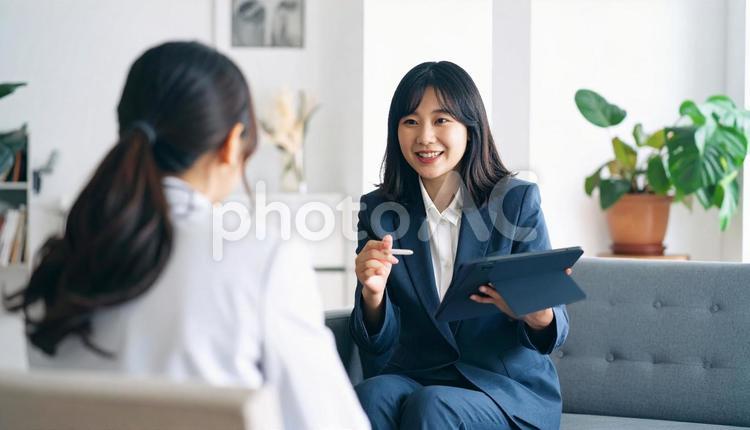 タブレットを使って説明する女性営業マン タブレット,女性営業マン,女性ビジネスマンの写真素材