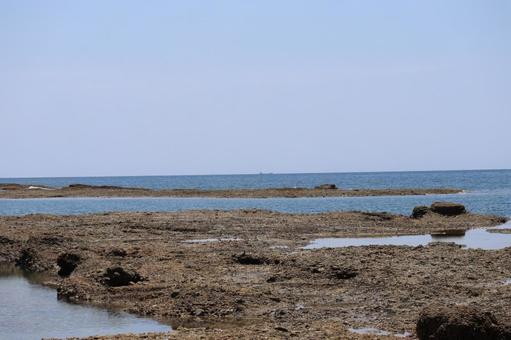 岩礁の海岸の浅瀬と青い海と船と水平線と空 岩礁,海岸,浅瀬の写真素材