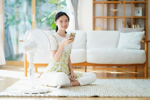 スマホを持ち涼む笑顔の女性 女性,スマートフォン,持つの写真素材