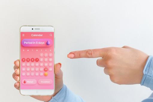 生理周期アプリ画面を指差す女性 生理,月経,女性の写真素材