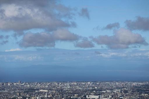 雲と青空と海と市街地の街並みと山並み 雲と青空と海と市街地の街並みと山並みの写真
