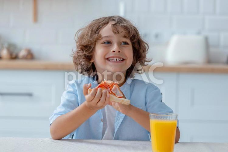 ピザを食べながら話す男の子 男の子,ピザ,持つの写真素材