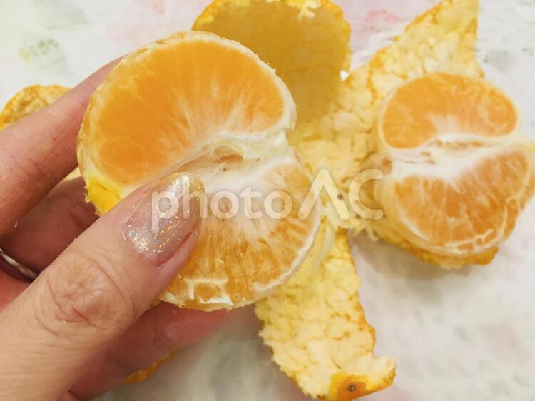 みかんを剥く女性の手 みかん,柑橘,ビタミンの写真素材