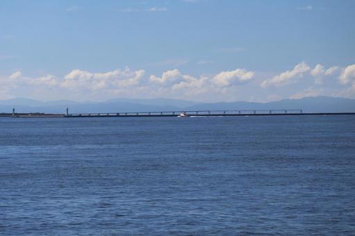 青空と雲と山と橋と船と青い海面の海の風景 青空と雲と山と橋と船と青い海面の海の風景の写真