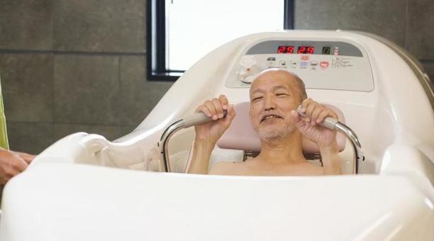 機械浴で入浴介助を受けるアジア人高齢者 機械浴で入浴介助を受けるアジア人高齢者 高齢者,機械浴,入浴の写真素材