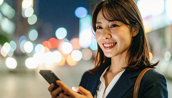 スマホを持つ日本人の若い女性の写真