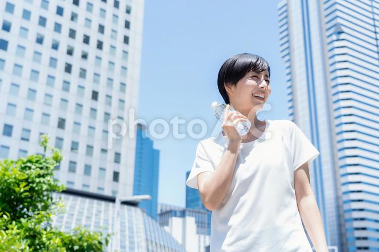 オフィス街をジョギングする若い女性 ランニング,ジョギング,フィットネスの写真素材