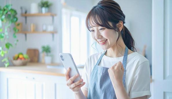 スマホでポイ活する笑顔の女性 スマホでポイ活する笑顔の女性の写真