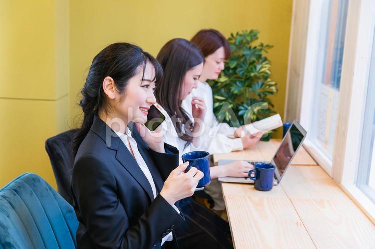 カフェの窓際カウンター席にいる女性（スマホ） スマホ,電話,スマートフォンの写真素材
