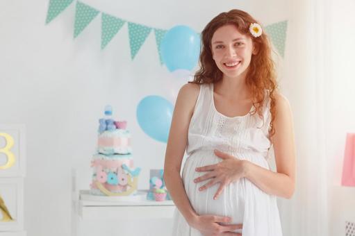 お腹を触る妊婦と日差し お腹を触る妊婦と日差しの写真