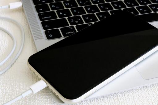 パソコンに繋がれたスマホ 同期 転送 パソコンに繋がれたスマホ 同期 転送の写真