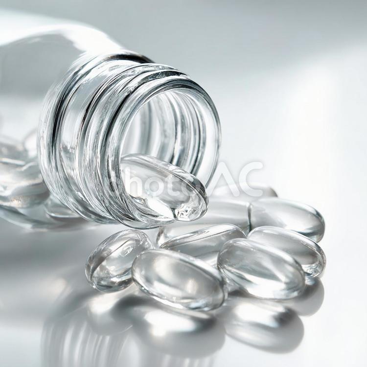 薬瓶からこぼれる透明なカプセル 薬,カプセル,サプリメントの写真素材