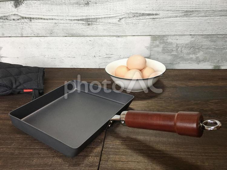 鉄製の卵焼き器と卵とミトン 卵焼き器,フライパン,鉄製の写真素材