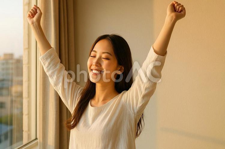 朝日に照らされながら伸びをする女性・朝活 朝活,女性,朝日の写真素材