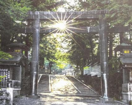 鳥居に太陽の光が射し込んでいる 鳥居,諏訪大社,秋宮の写真素材