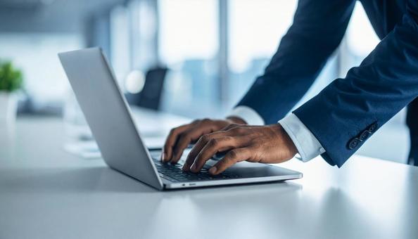 ノートPCを操作するビジネスマンの手元の写真