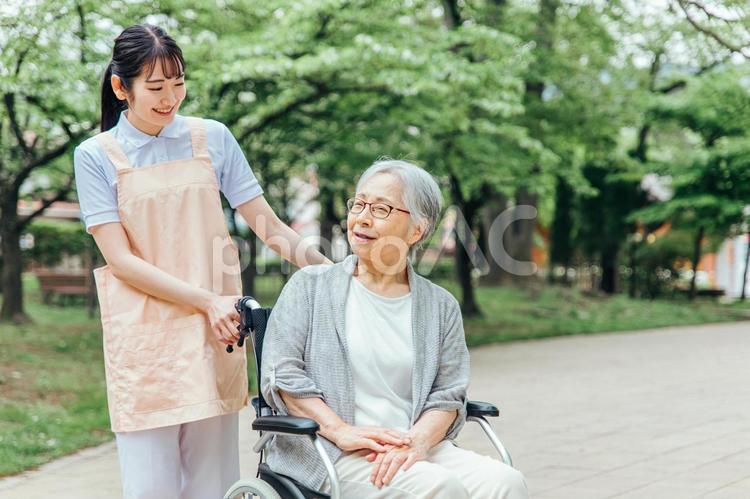 車椅子に乗った高齢者女性と女性スタッフ 介護,老人ホーム,看護師の写真素材