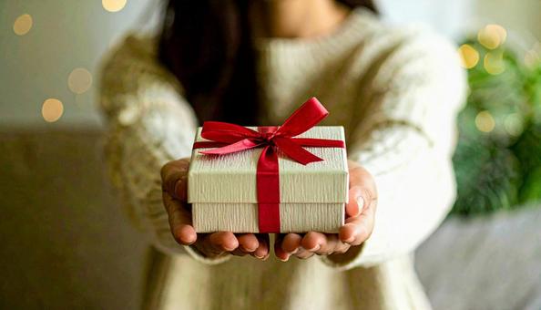 白い箱のプレゼントを両手に取る女性の手 白い箱のプレゼントを両手に取る女性の手の写真