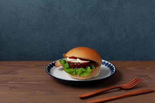 お皿にのせたテリヤキバーガー テーブル お皿にのせたテリヤキバーガー テーブルの写真