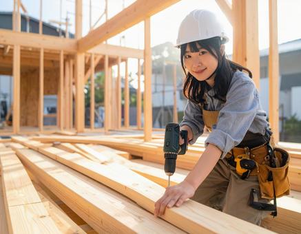 家を建築中の若い女性大工 家を建築中の若い女性大工の写真