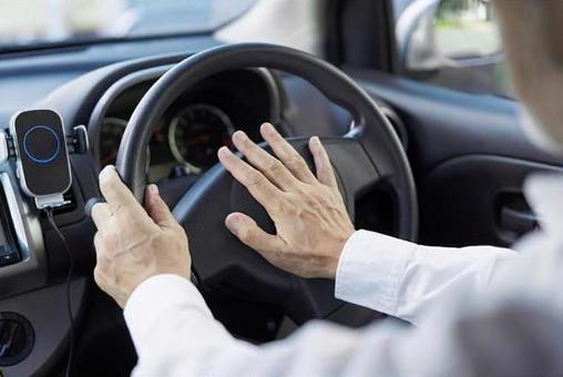 一個老人按汽車喇叭的後視圖 一個老人按汽車喇叭的後視圖