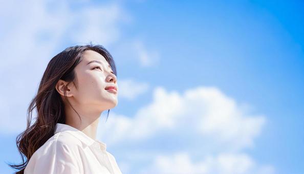 青空を見上げる女性の横顔 青空を見上げる女性の横顔の写真