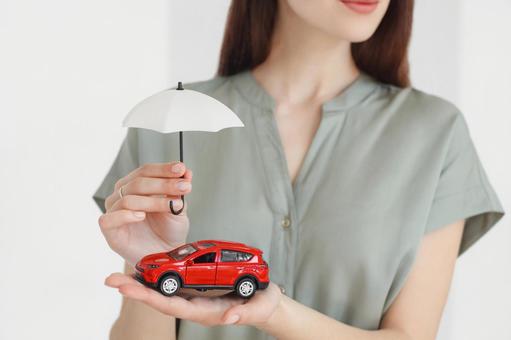 傘で赤い車を守る様子の手元 保険業,事務職,接客業の写真素材