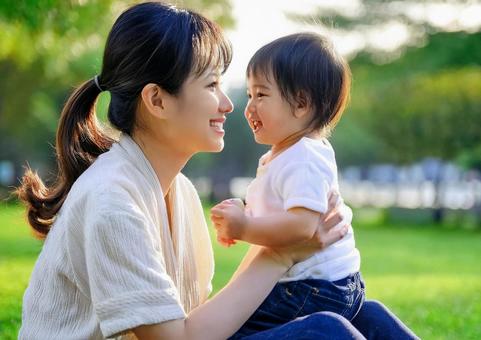 緑の中で遊ぶ、子と母親 緑の中で遊ぶ、子と母親の写真
