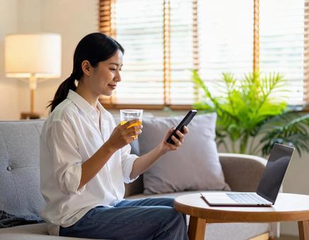 自宅のソファでリラックスする女性の写真